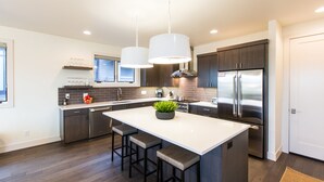 A modern kitchen with a large island, stainless steel appliances, and pendant lighting. - SPACIOUS ~ 24-hr staff ~ clean + modern ~ wifi ~ parking ~ hot tub ~ firepit 🐶 (Bend)