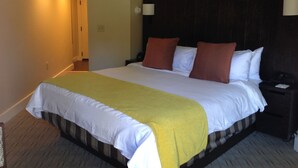 Une chambre d’hôtel avec un grand lit, une table de chevet et une petite table d’appoint.