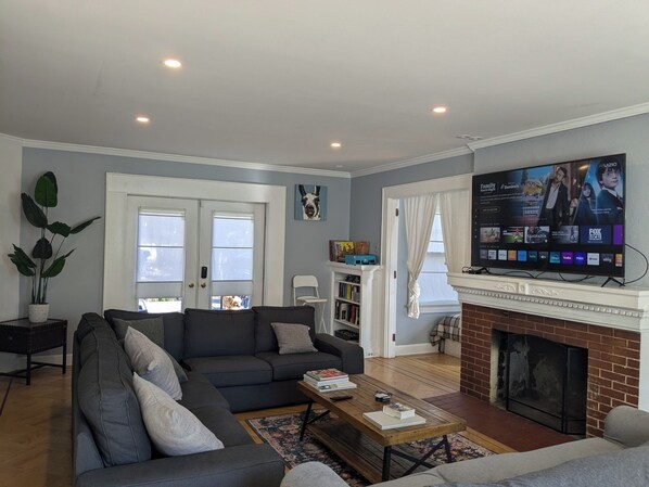 TV connectée, cheminée, livres, médiathèque