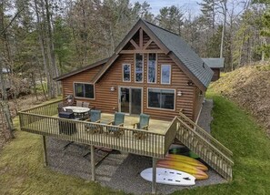 A log cabin with a deck, outdoor seating, and a kayak. - Crystal Clear Water, UTV Trail & Free Firewood! (Eagle River)
