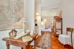 Experience a traditional ambiance in this well-appointed room featuring a comfortable bed, ornate sideboard, and intricate tapestry.