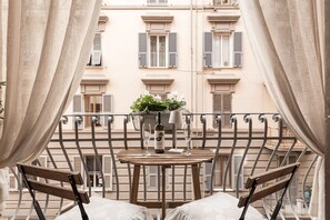 Enjoy a peaceful view from this balcony with a small table and chairs, perfect for taking in the sights.