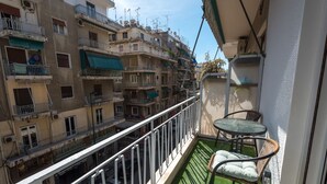 A balcony with a small table and chairs, overlooking a densely packed urban area with multiple buildings. - Tonia's house in Athens (Athens)
