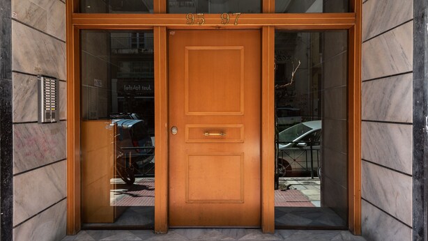 A wooden double door with the numbers 95 and 97 above it, set in a building with tiled walls. - Tonia's house in Athens (Athens)