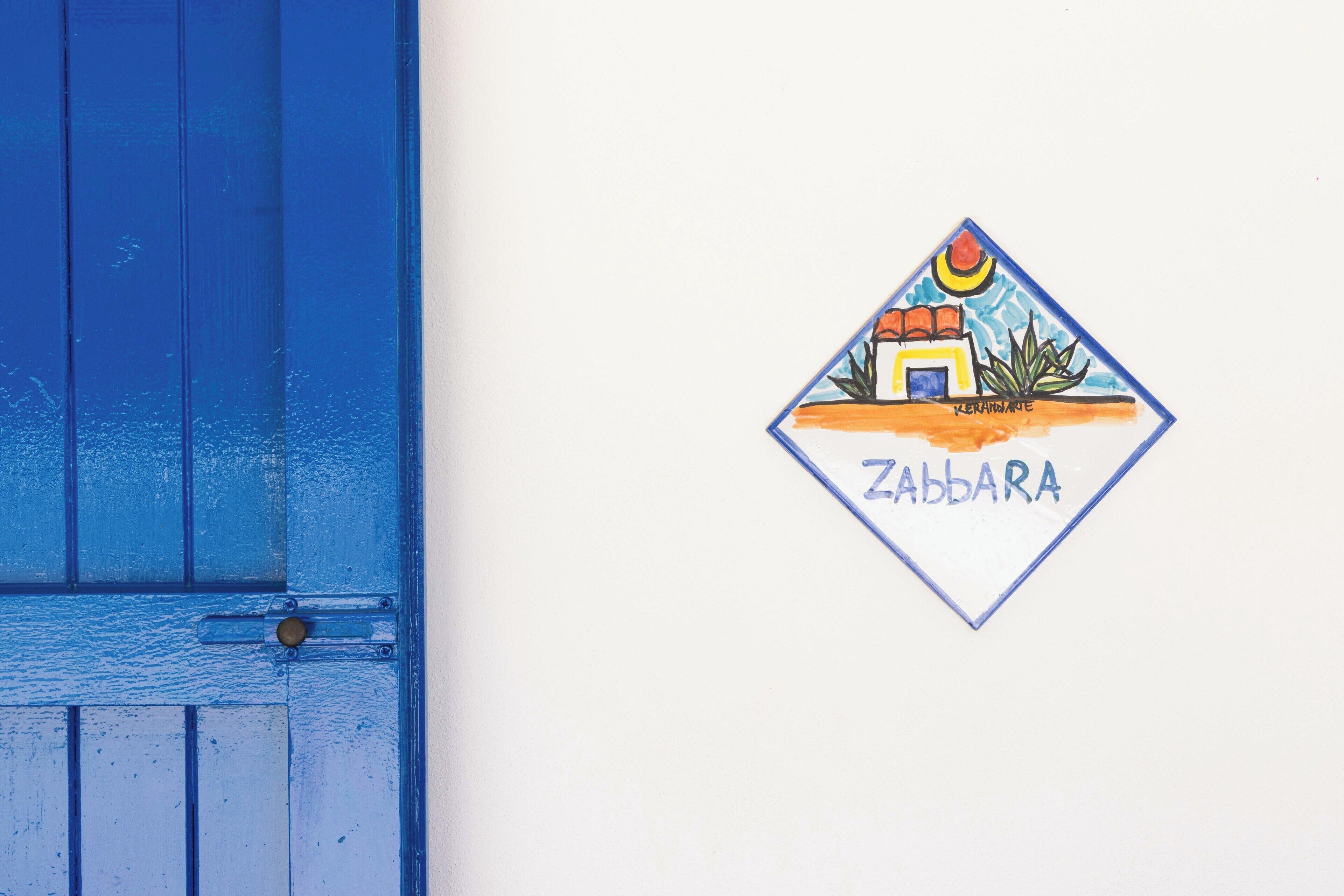 A blue door and a wall with a Zabbara logo.