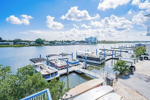 A marina with boats docked, a clear sky, and a distant building.