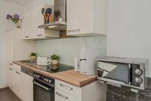 Eine moderne Küche mit Einbauofen, Kaffeemaschine und Mikrowelle.