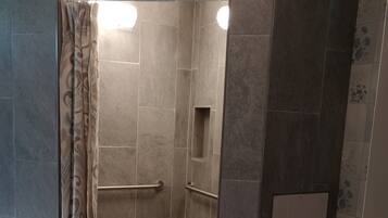Een bad/douchecombinatie, een bidet, handdoeken, zeep
