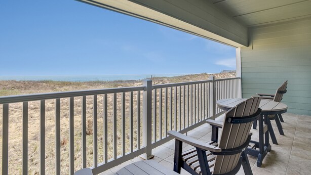 A covered outdoor seating area with a view of the beach. - Love at First Flight: Oceanfront, Shared Pool (Kill Devil Hills)