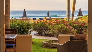 An open patio with a view of the ocean, outdoor furniture, and a small garden area. - Surf & Stay; Beachfront Condo Steps from Sand - Heated Hot tub -Pool-Pickleball (San José del Cabo)