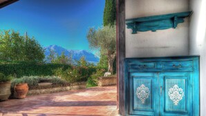 A blue cabinet with ornate designs, a tiled patio, and a mountainous backdrop. - Sarkeep - Villa Immersed in the vineyards of Taurasi (Luogosano (Avellino))