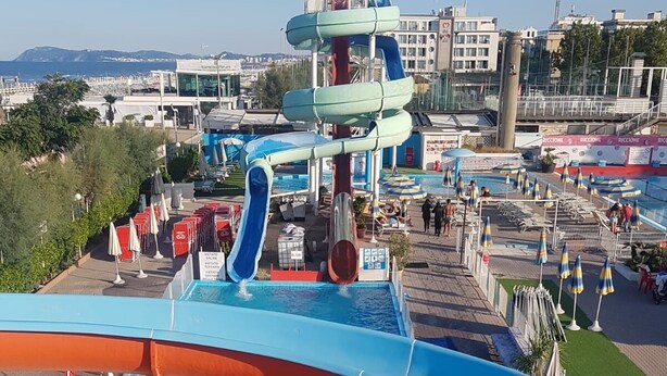 A water park with multiple slides and pools, surrounded by umbrellas and lounge chairs. - RICCIONE with BEACH and AQUAPARK INCLUDED /BEACH and AQUAPARK included !!! (Riccione)
