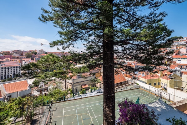 Residents can enjoy a game of basketball in the enclosed court surrounded by trees and buildings with red-tiled roofs.