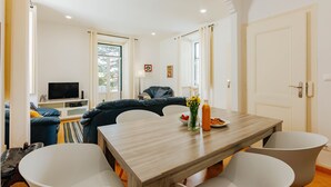 Een moderne woonkamer met een eettafel, een bank en een televisie.