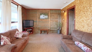 A log cabin-style room with two sofas, a television, and a small table. - Love Shack - Location and views this property has it all (Robe)