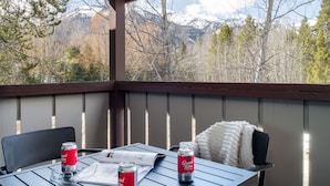 A covered patio with a table, two chairs, and two cans of Grand Theft Auto beverage.