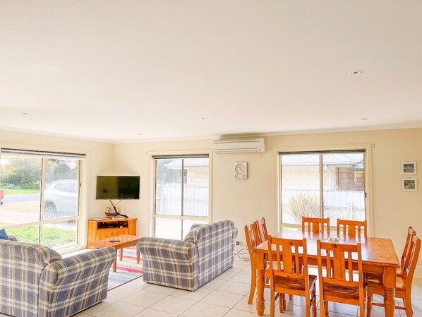 Relax in this spacious living area with a dining table for six, comfortable sofa, and flat-screen TV.