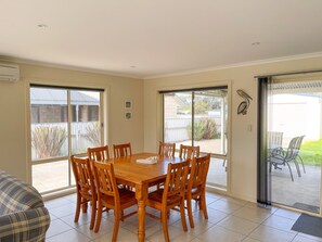 Relax in this inviting dining area with a large table and comfortable seating for six, leading out to a patio.