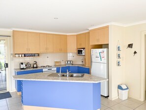 Enjoy cooking in this well-equipped kitchen with a central island, sink, and stove.