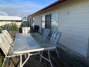 Enjoy al fresco dining or relaxation on this outdoor patio with a glass-top table and comfortable seating for four.