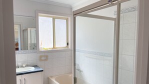 Ein Badezimmer mit Badewanne, Dusche und Waschbecken.