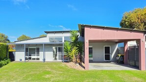 A modern two-story house with a covered patio, a fenced backyard, and a clear blue sky. - Sun on Sanders - Modern 2 br house close to main street. Pet Friendly Outside (Robe)