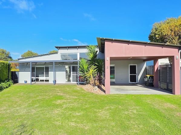 A modern two-story house with a covered patio, a fenced backyard, and a clear blue sky. - Sun on Sanders - Modern 2 br house close to main street. Pet Friendly Outside (Robe)