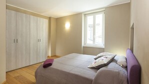 A bedroom with a bed, a wardrobe, a window, and a nightstand. - LUCIA by KlabHouse-Central  lakeview w/AC  (Bellagio)