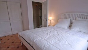 A bedroom with a bed, a nightstand, a lamp, and a shower area. - Apartment for 4 people - Swimming pool - Air conditioning - WiFi - Sainte Maxime (STE MAXIME)