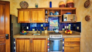 Una cocina con armarios de madera, una estufa de acero inoxidable y un salpicadero de azulejos azules.
