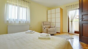A bedroom with a bed, a massage chair, a wardrobe, and a door. - Comfortable villa with private pool near sandy beach (Medulin)