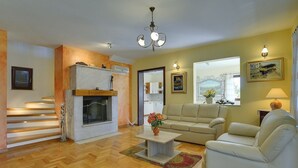 A living room with a fireplace, sofa, and a staircase. - Comfortable villa with private pool near sandy beach (Medulin)