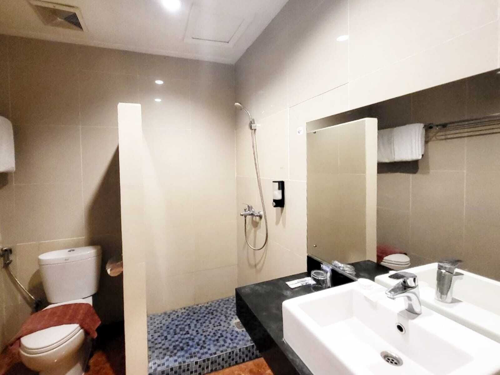 A bathroom with a shower, toilet, and sink.