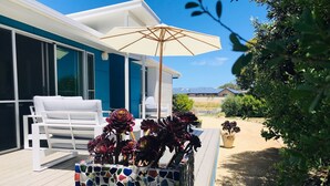 A modern outdoor deck with a white chair, a mosaic planter with succulents, and a patio umbrella. - Blauhaus - Relax all your blues away... (Robe)