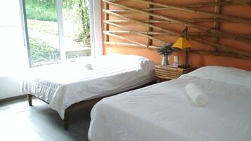 Habitación cuádruple, 2 camas matrimoniales, vista al jardín | Cortinas blackout y ropa de cama