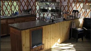 Una cocina con armarios de madera, una isla central y una ventana con celosía.