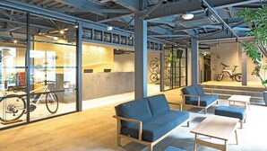 Un espacio interior con asientos, una zona de recepción y bicicletas.