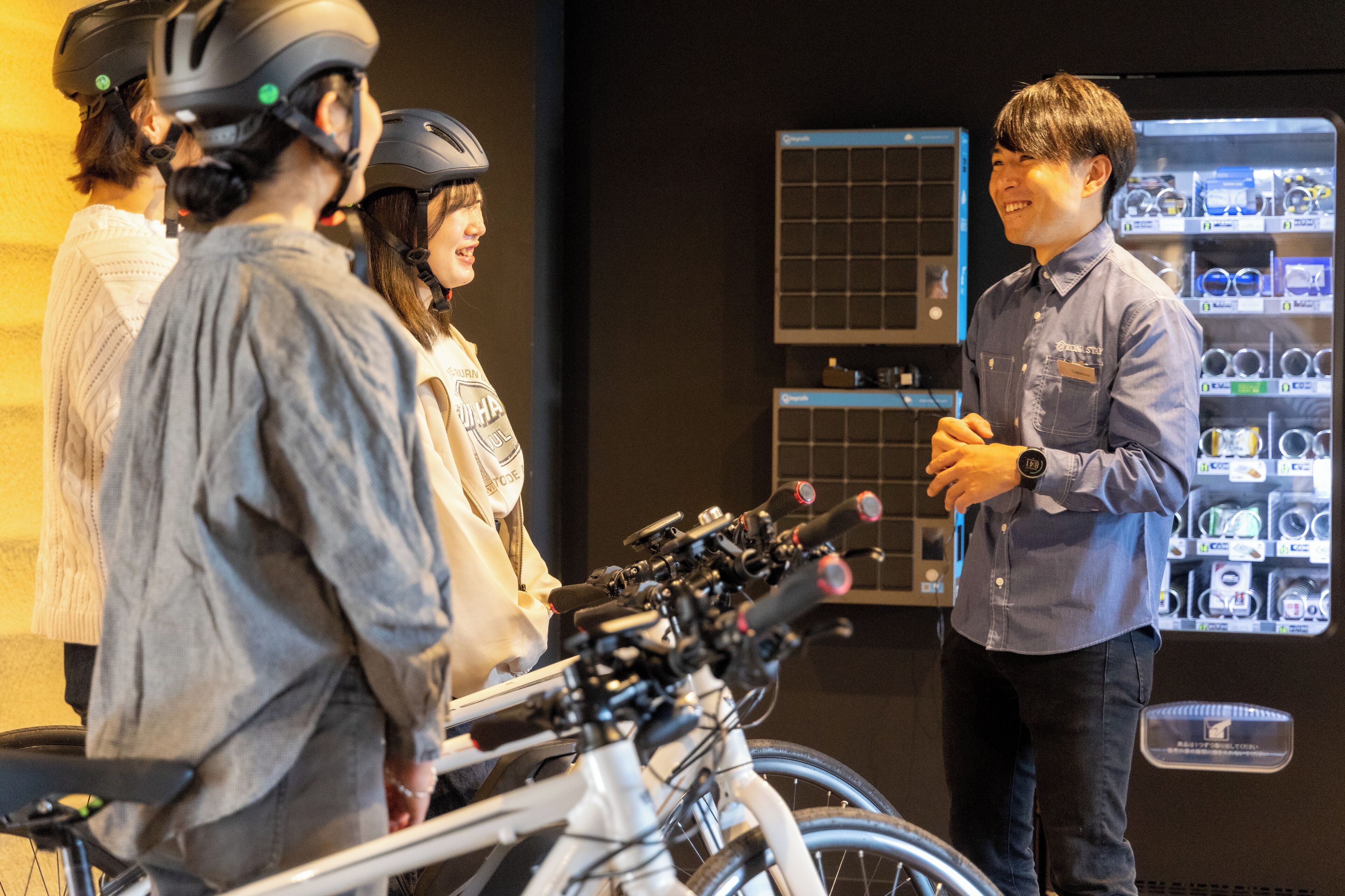 A group of people standing in front of bicycles and a display of eyeglasses.