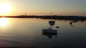A calm harbor with several boats anchored, a clear sky, and a distant shoreline with buildings. - Independent studio + enclosed garden in Penmarc'h. Plage du Ster 800m away, laTorche 5 kms away (Penmarch)