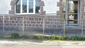 A building with a stone facade, a large arched window, and a metal handrail. - Independent studio + enclosed garden in Penmarc'h. Plage du Ster 800m away, laTorche 5 kms away (Penmarch)