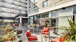 An outdoor patio area with seating, tables, and planters. - Hilton Garden Inn Toronto Brampton West (Brampton)