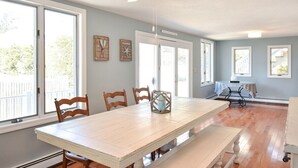 A dining area with a large table, wooden chairs, and a ceiling fan. - 400 Yards to the Beach! Dogs Welcome! (Dennis Port)