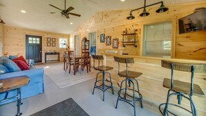 Interior acogedor de una cabaña con comedor, cocina y sala de estar.