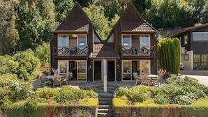 A symmetrical building with balconies, a stone pathway, and a pond.
