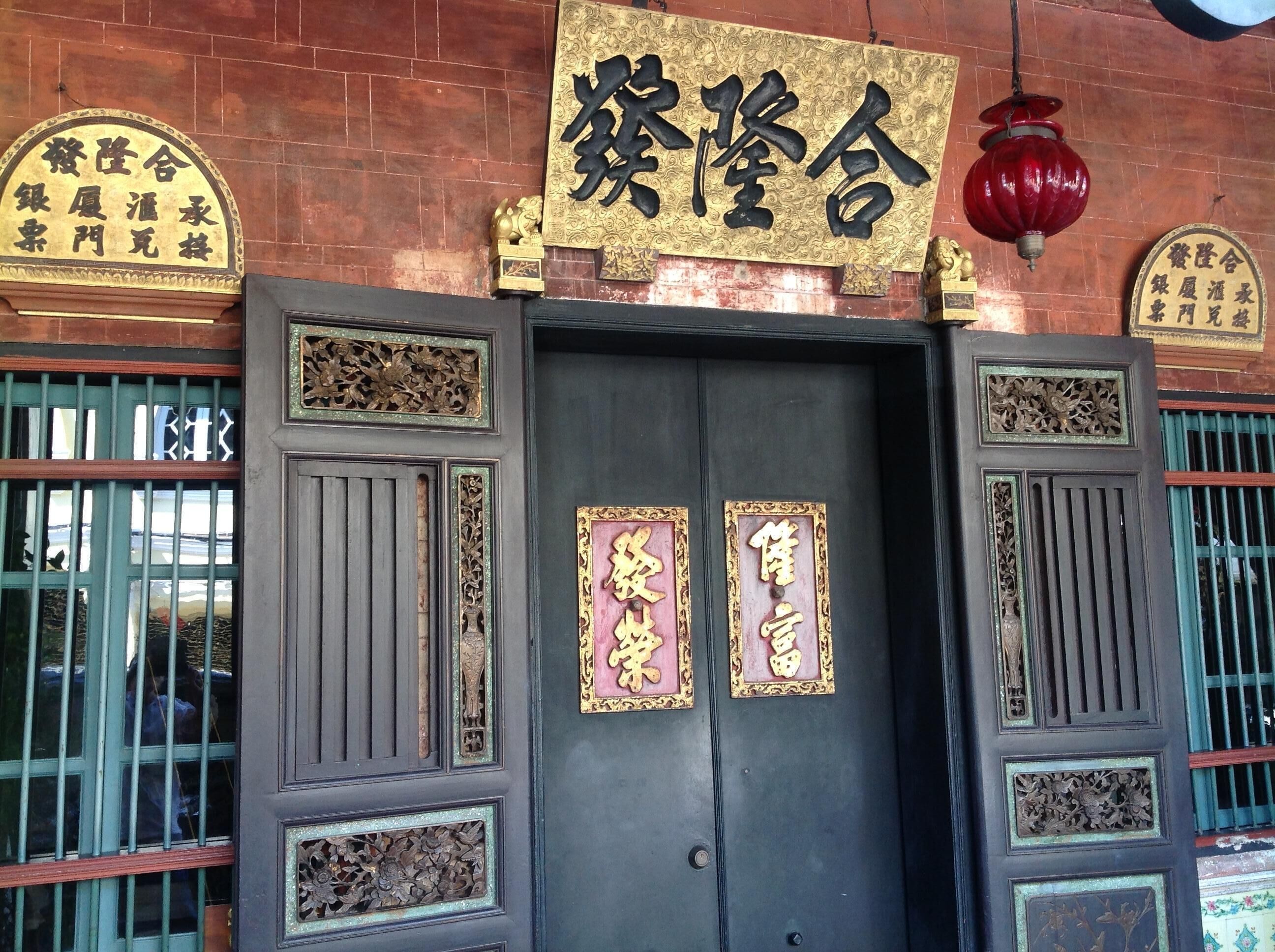 Ein traditionelles chinesisches Tor mit aufwendigen Schnitzereien und goldenen chinesischen Schriftzeichen.