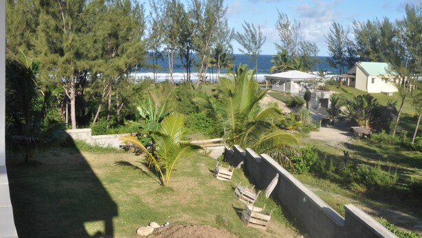 A coastal property with a view of the ocean, surrounded by tropical vegetation and a few buildings. - Villa Tambatra (Mahavelona)