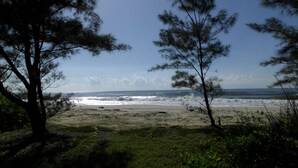 A beach with trees in the foreground and the ocean in the background. - Villa Tambatra (Mahavelona)