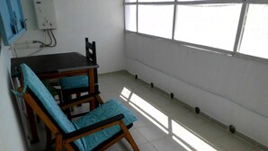 A small room with a table and two chairs, a window, and a wall-mounted electrical box. - Villa Tambatra (Mahavelona)