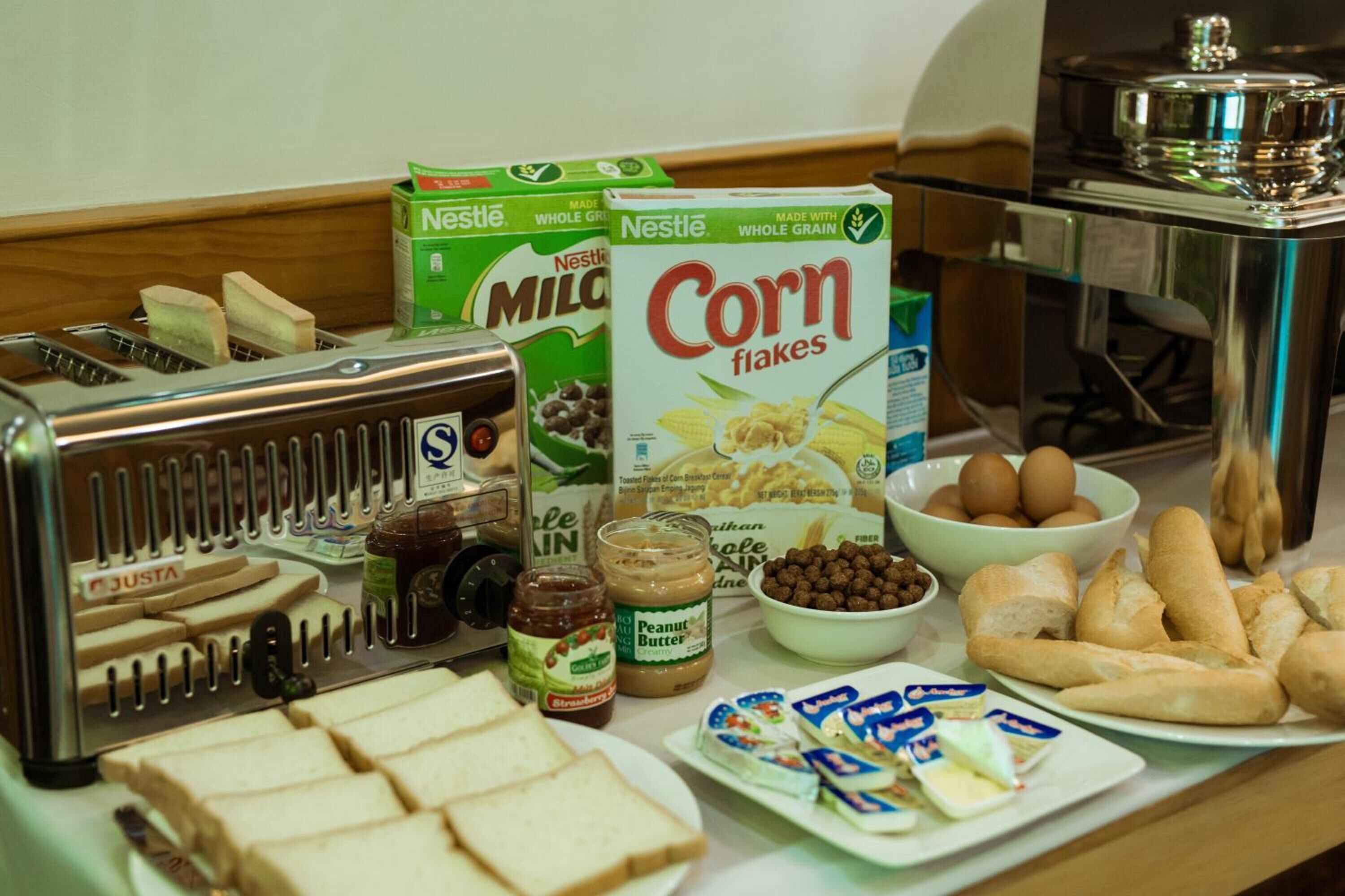 A breakfast setup with cereal, bread, peanut butter, and eggs.