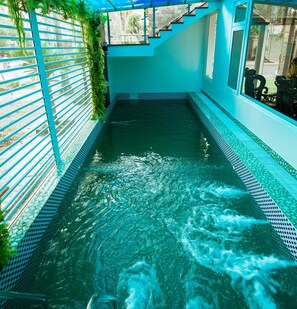 A swimming pool with a blue tiled edge, surrounded by a blue railing and a staircase leading to a covered area. - Tuyet Suong Villa Hotel (Nghia Lo)